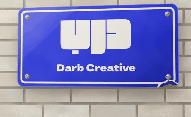 An enamel street plate reading Darb Creative on a brick wall