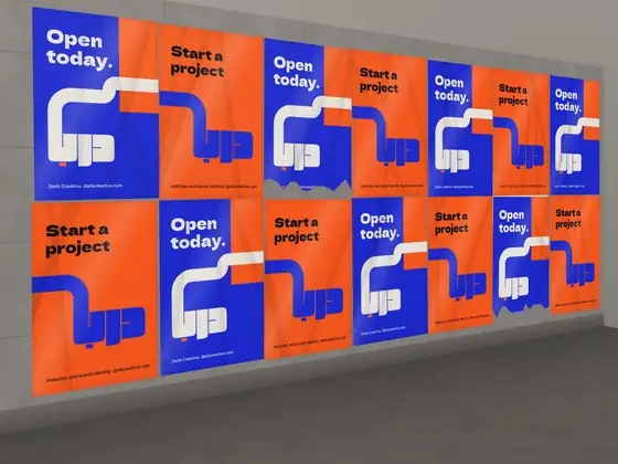 A wall of wheatpasted posters in orange and blue for launch day