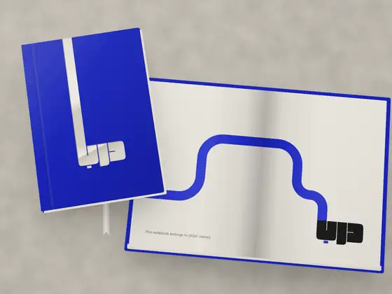 A blue cloth notebook with a foil mark, and an open copy