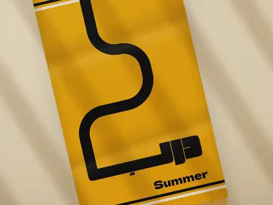 A saffron beach towel with the path and mark, the summer guest colour